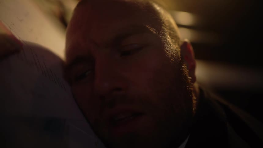 Person laying on a floor in a dim room opens his eyes and blinks