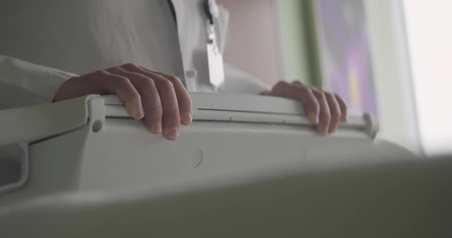 A person in a lab coat leans against a machine