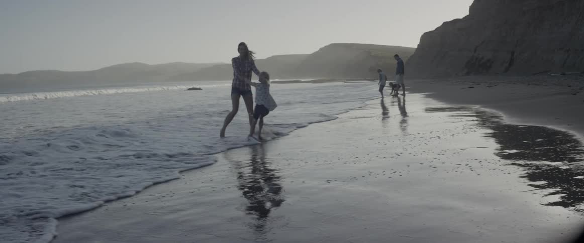 A family are having fun on the beach on a foggy day