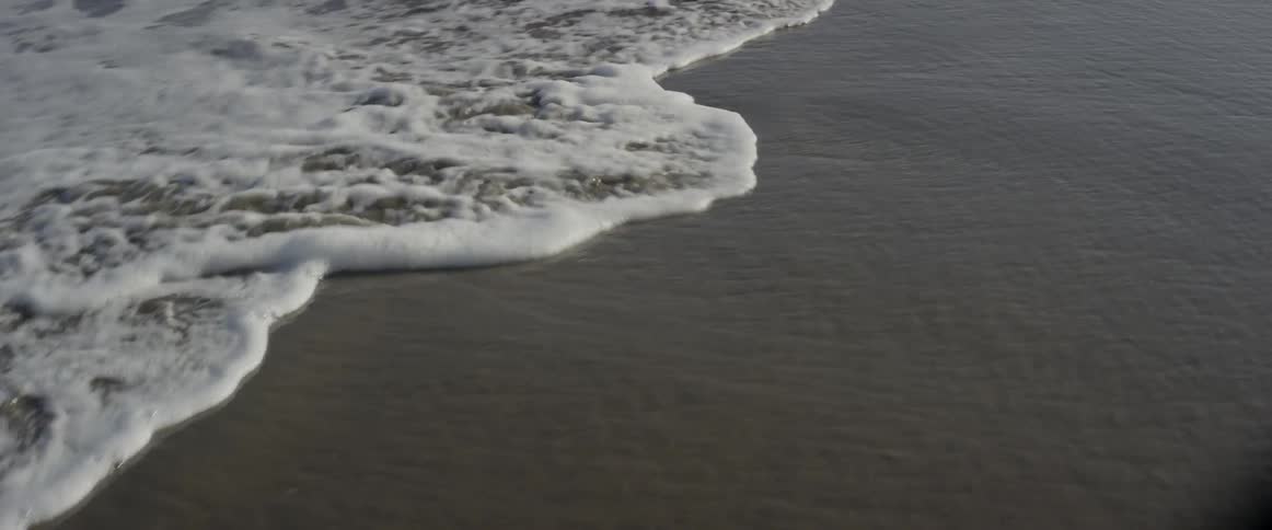 Frothy waves roll in to the shore