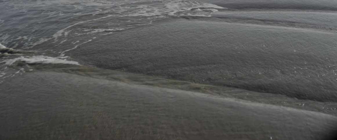 Ocean water flows over sand
