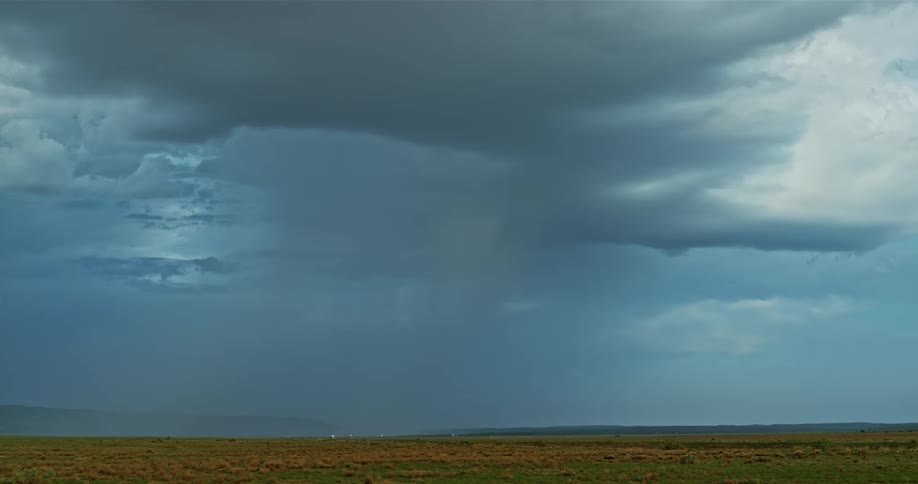 Lightning flashes and strikes the ground as a storm moves across a prairie