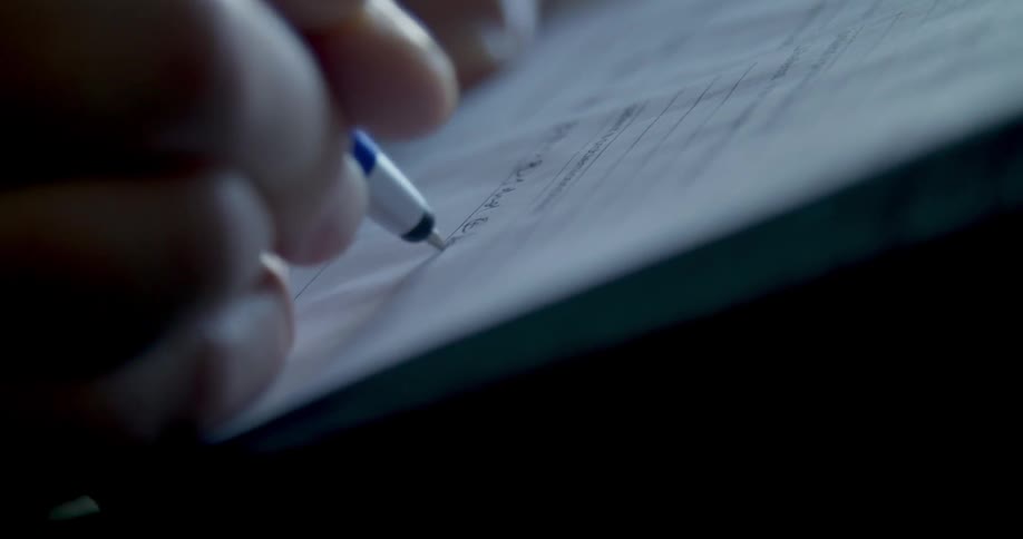 A man fills out a form with a pen