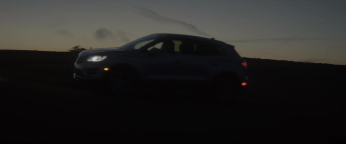 An suv with headlights on travels off road