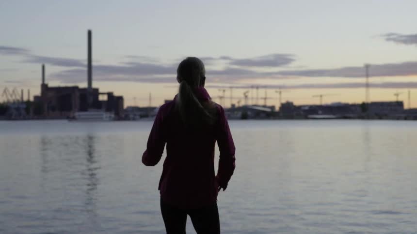 A young lady takes a mindful break after finishing her outdoor evening run.