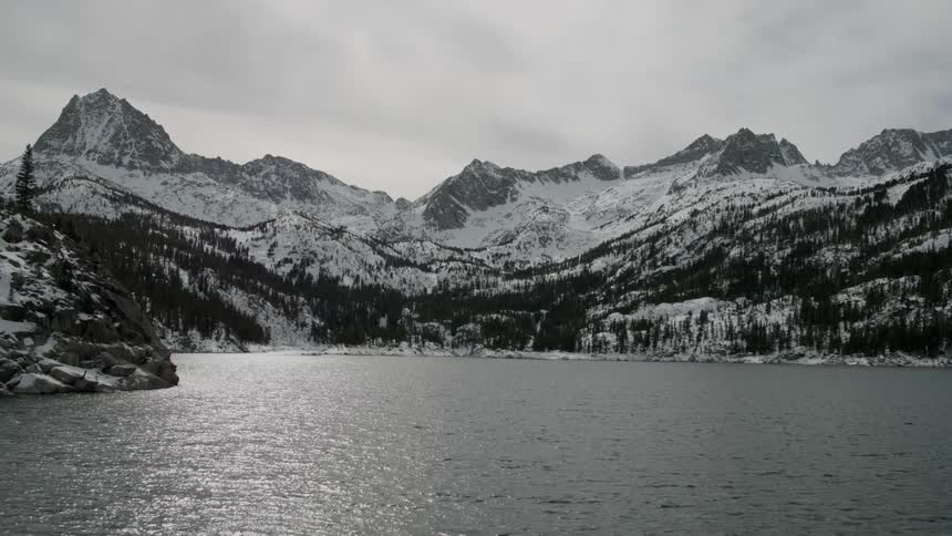 Lake sits near the snow covered mountains