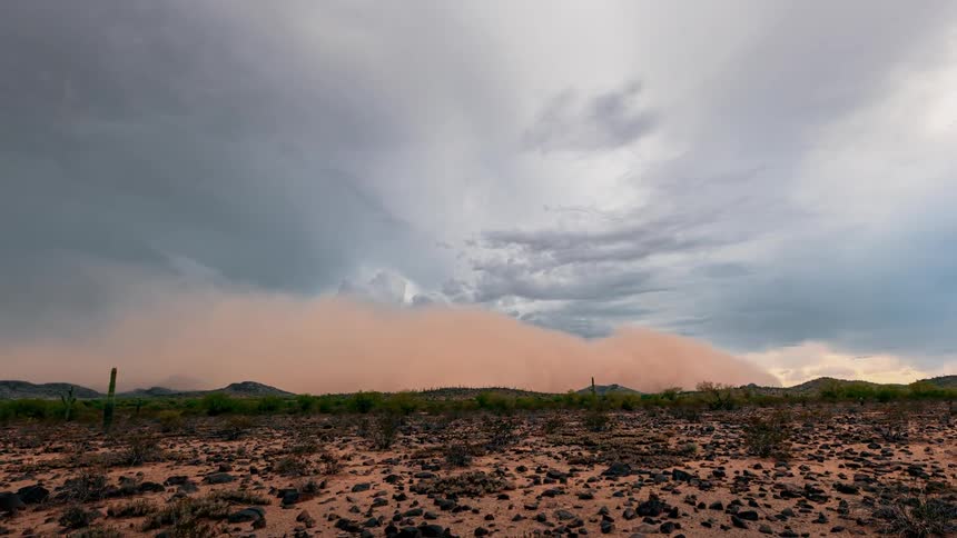 A dust storm rolls over a rural field