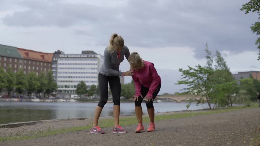 Woman assists another woman who appears to be injured