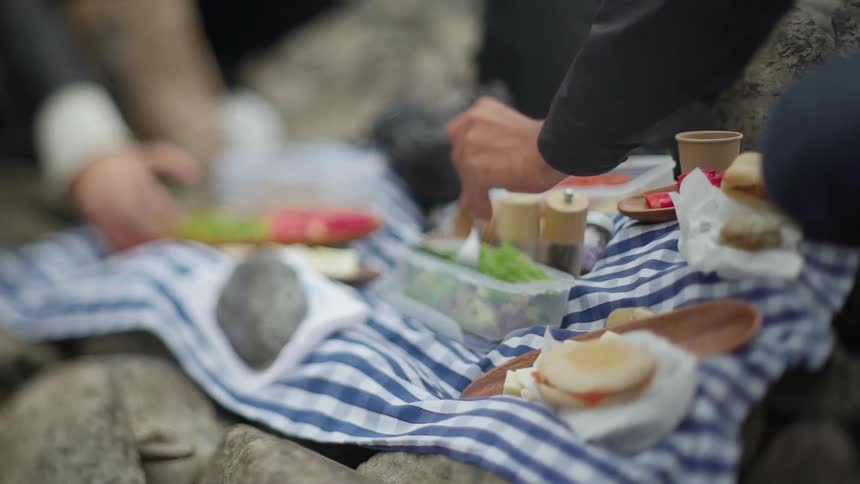 People eat a picnic on rocks