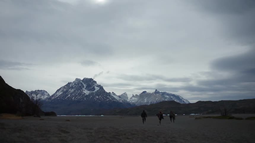 A group of people run towards the mountain together