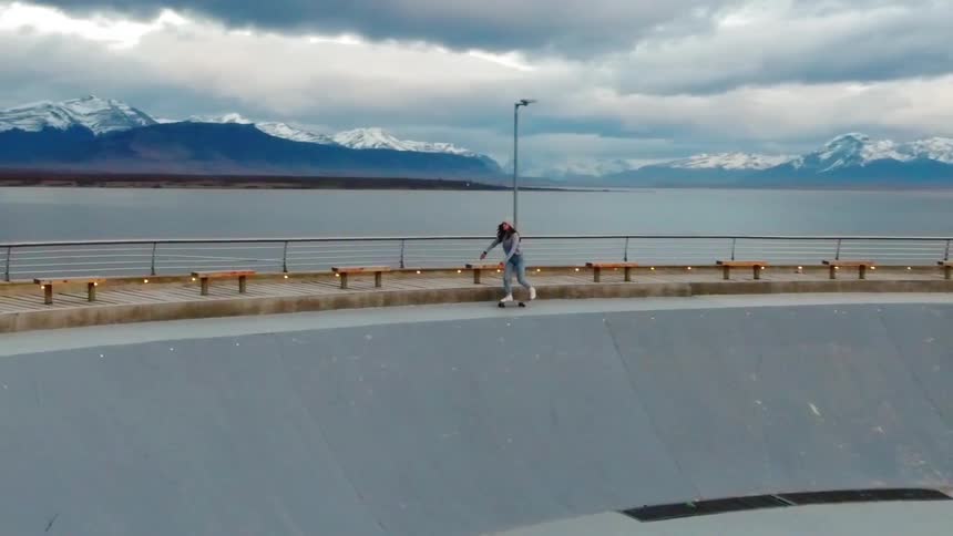 A person rides their skateboard around a rink
