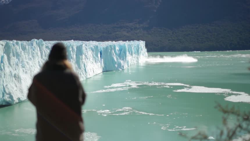 A woman looks at an icy lake