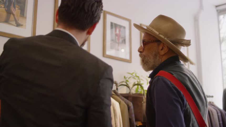 Two people are looking at clothing together in a shop