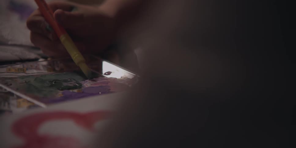 Close up of a person painting with many colors