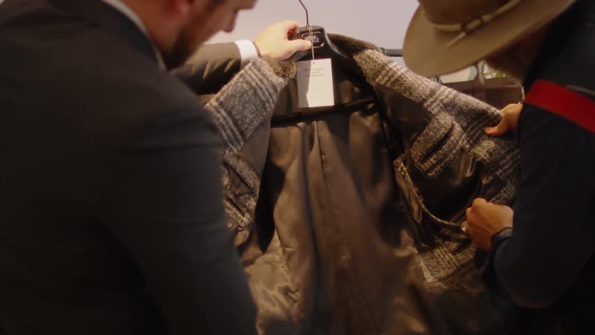 Two men look at some clothing in a store