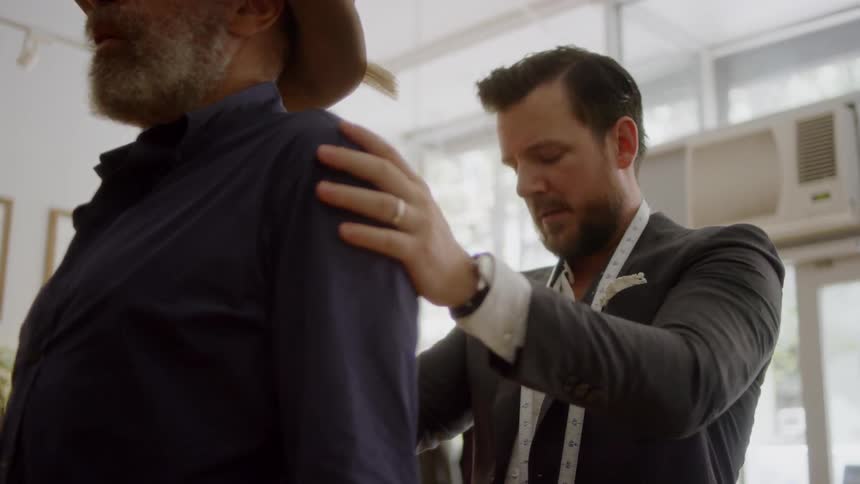 A man is being fitted for some clothing