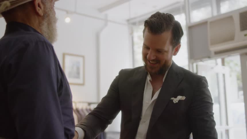 A tailor measures a man's waist