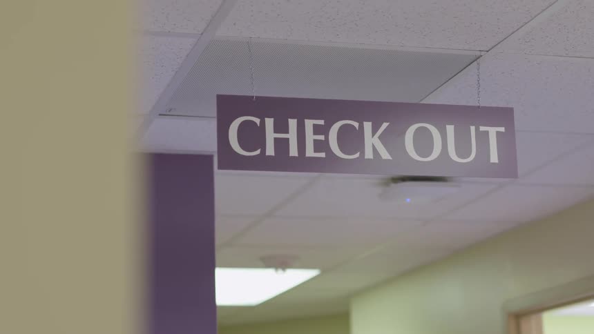 The sign hanging from the ceiling reads check out