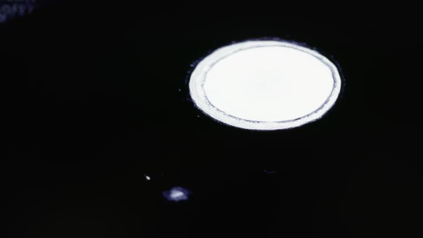 White images and lights are projected onto a black surface