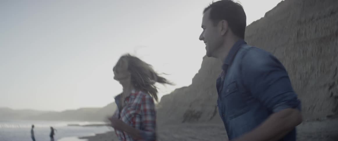 Man and woman jog on the beach