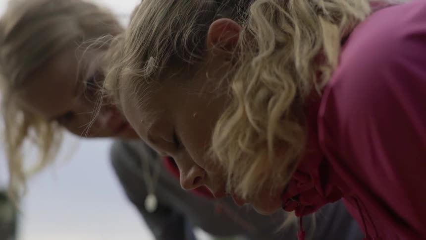Two blonde fitness partners share a difficult moment of exhaustion during an outdoor run.
