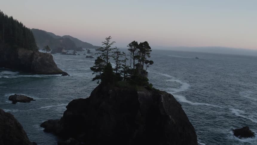 Waves crash into the base of a mountain