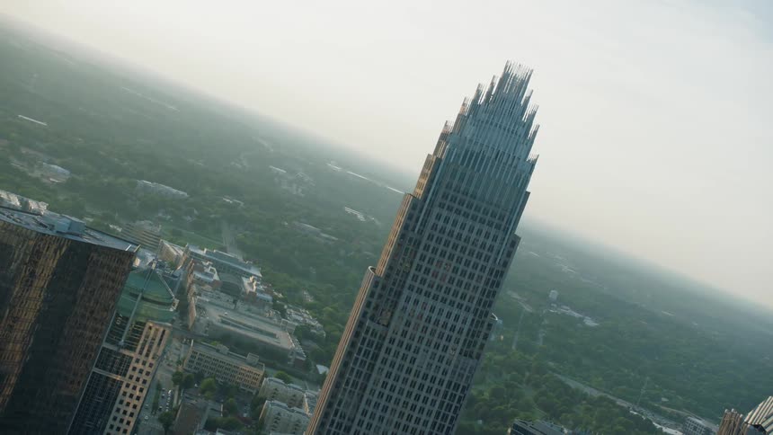 A huge building stands surrounded by smaller building in the middle of the city