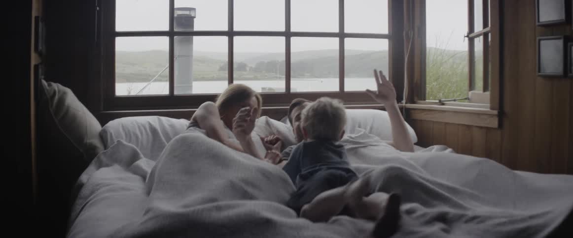 A child runs through the hallway jumping into his parents bed