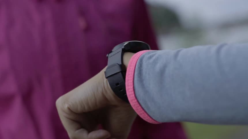 A person checks her daily heart rate metrics on a wrist tracker device.