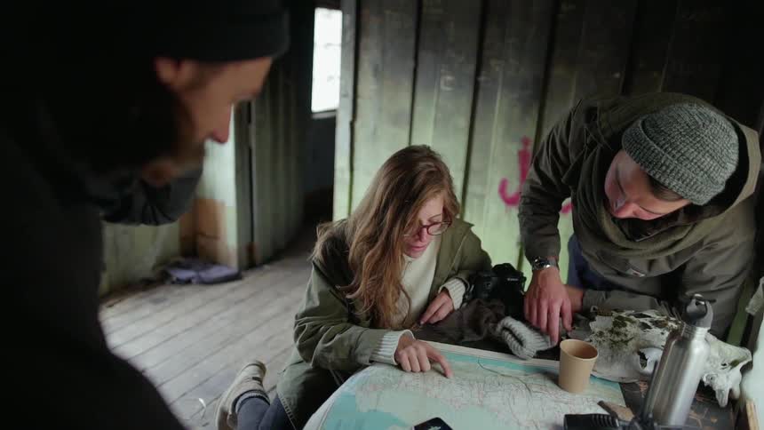 Woman looks at a map with two men