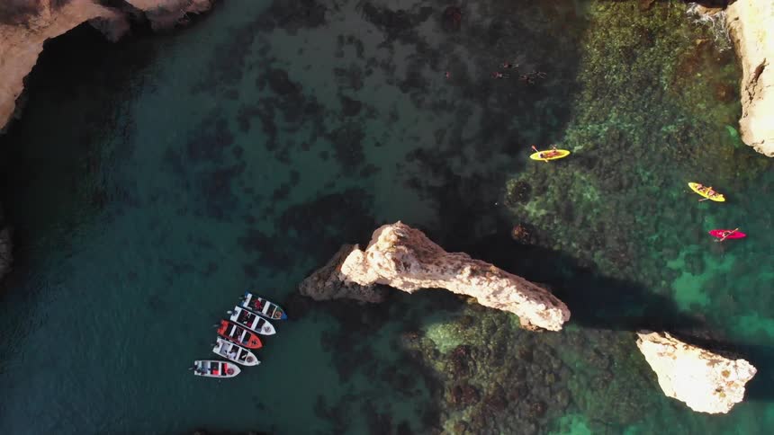 Kayakers are paddling down a river in a canyon on a sunny day