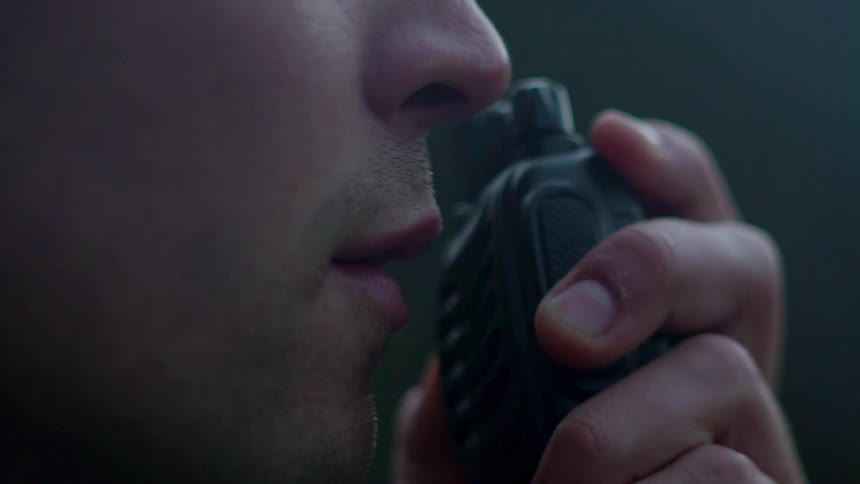 A man is talking into a walkie talkie