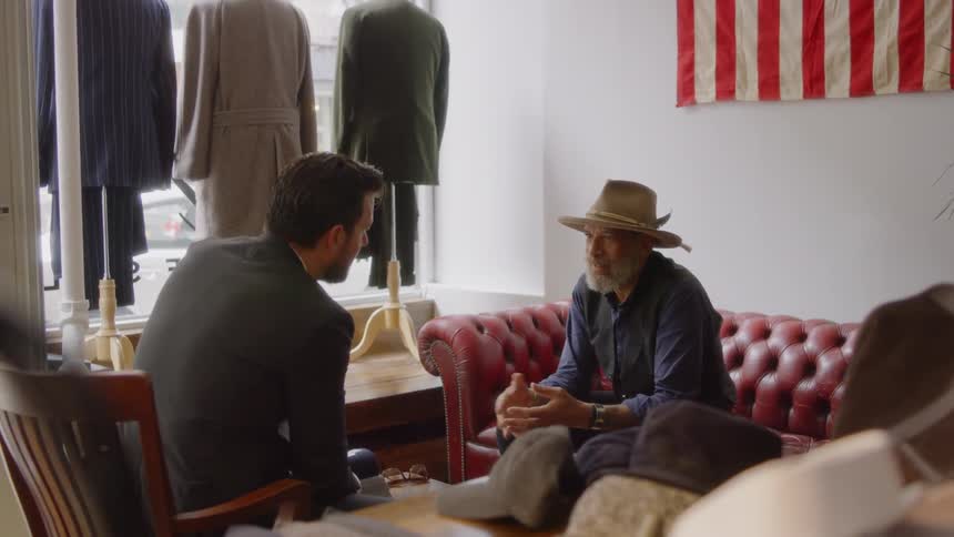 Two men talk in a clothing store