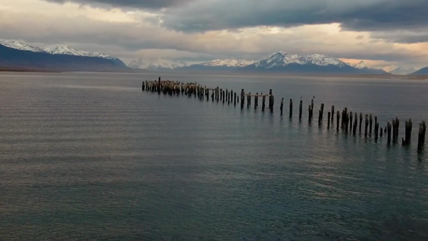 Wood poles extend into a mountain lake