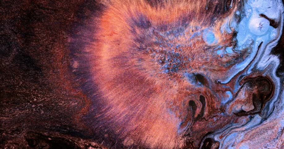 Colored liquid spreads around colored swirls