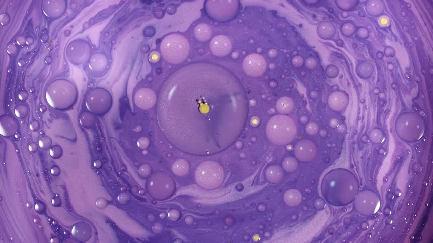 Yellow pills in swirling and bubbly purple paint