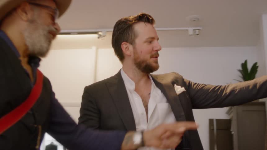 Two men hug and then examine a jacket