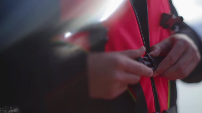 A person buckles a life vest