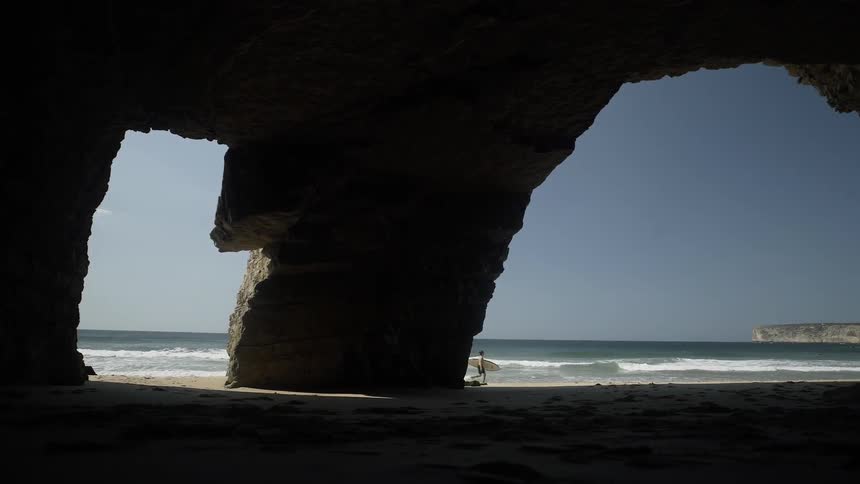 A man runs past the waves with a surfboard