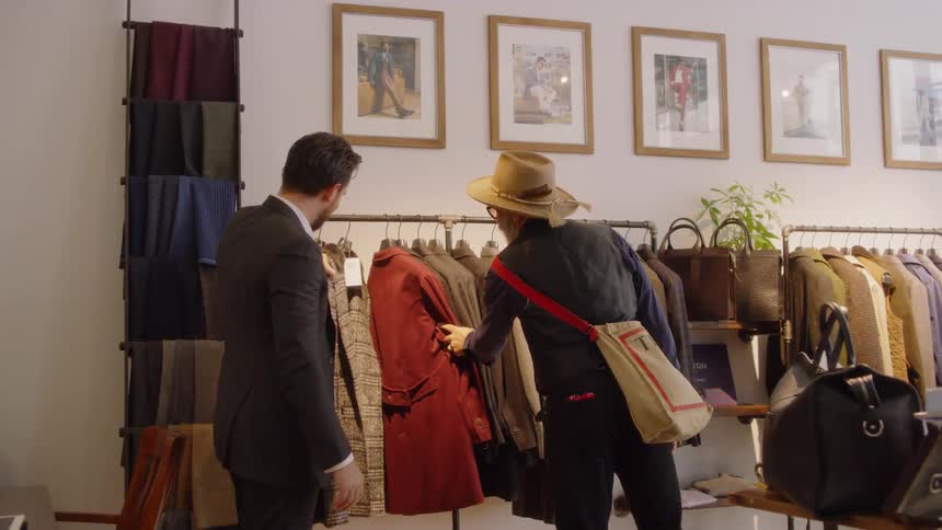 A salesman shows a jacket to a customer