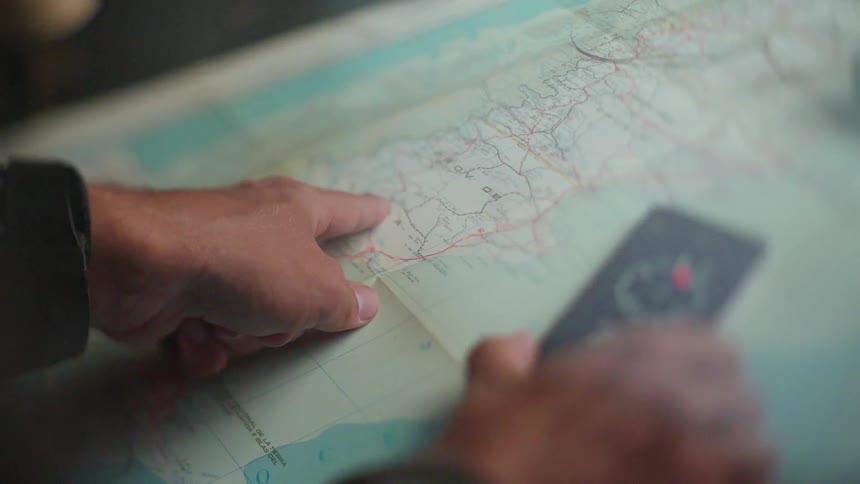 A person traces a route on a map with their finger
