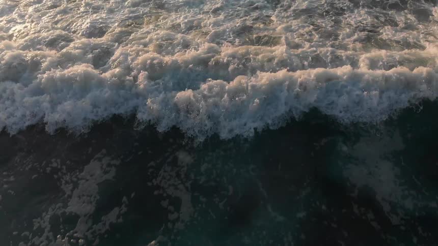 Frothy waves roll in to the shore