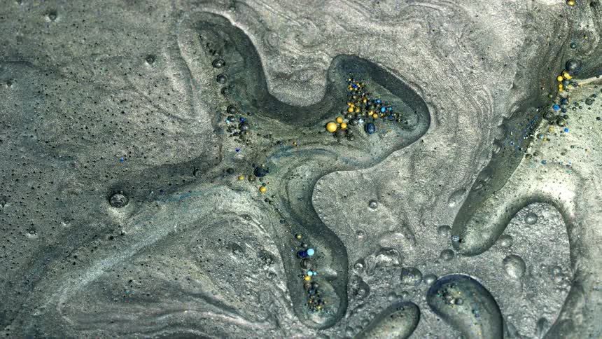 Metallic paint is mixing and spreading with little beads all over
