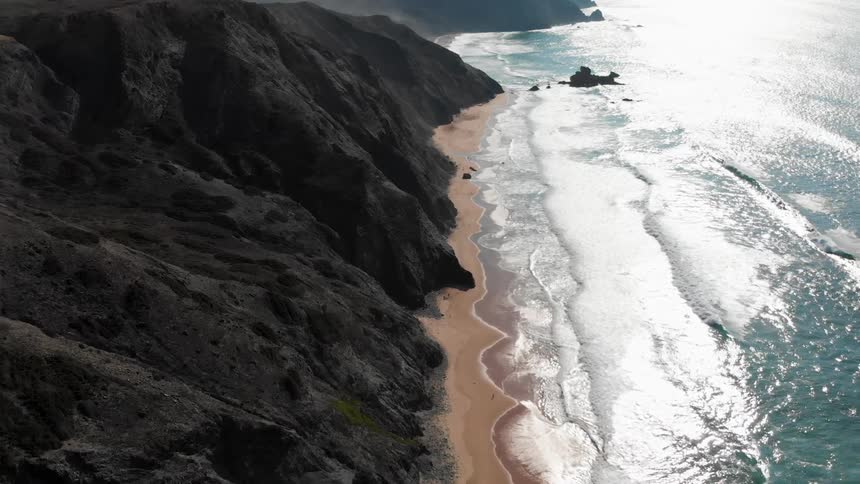 The large waves crash against the shore