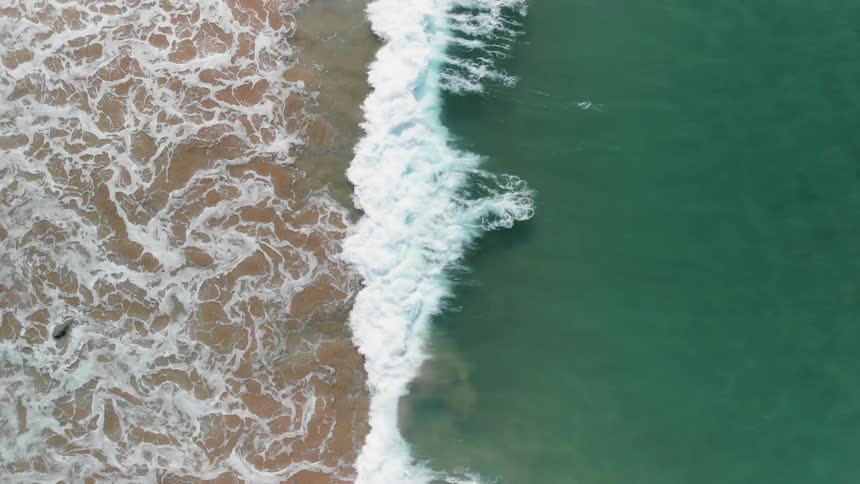 Ocean waves wash ashore a sandy beach