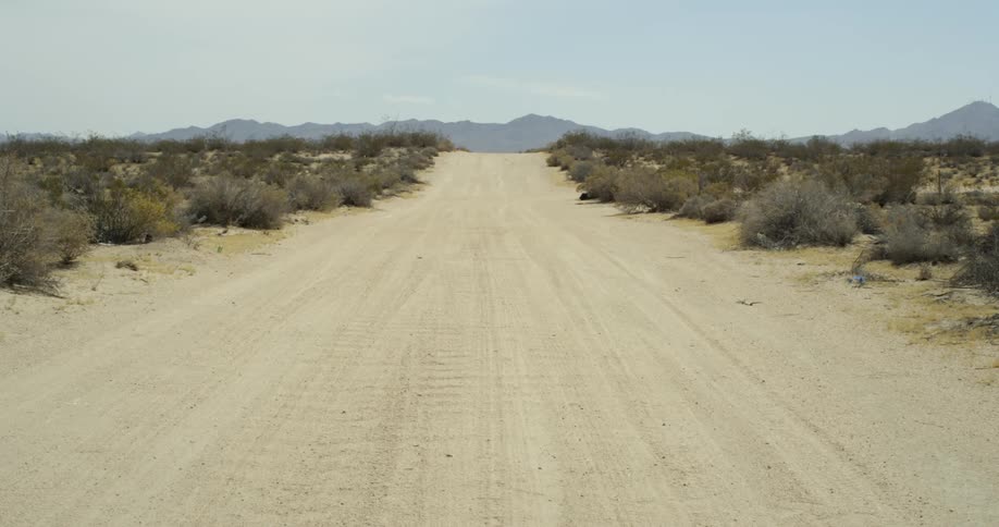 A dirt road runs through a desert