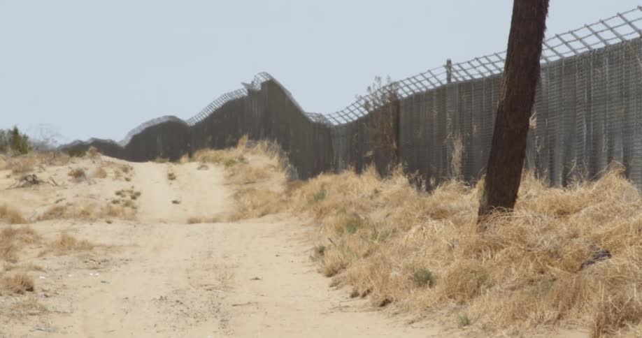 A bumpy dirt road and fence in the desert