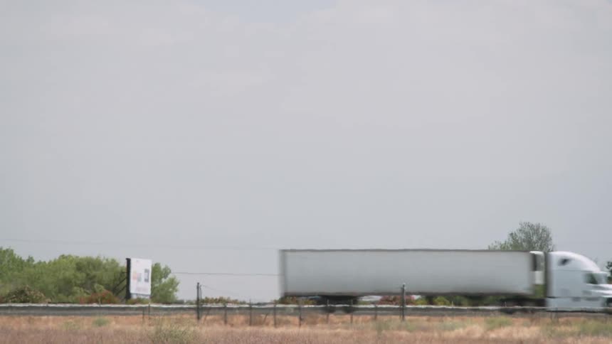 Vehicles are traveling on a rural interstate during the day