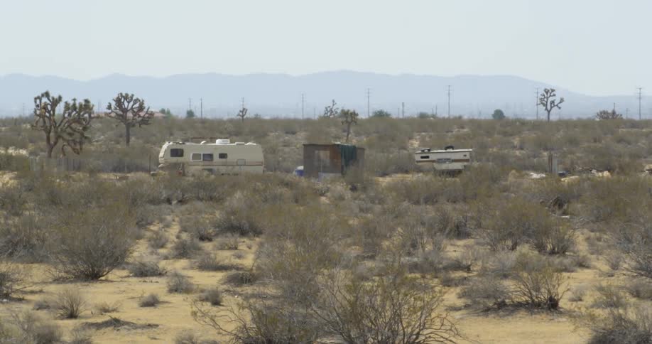 Campers are parked in a desert