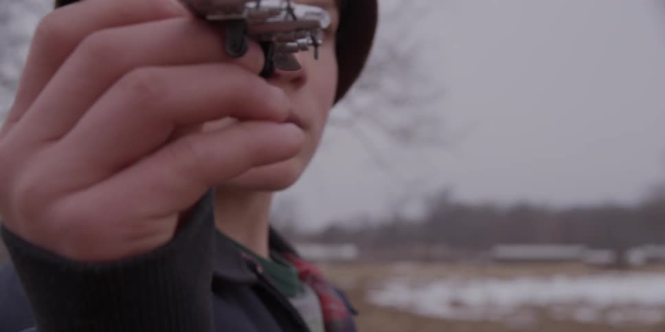 A boy wearing a helmet and holding a toy airplane pretending that it is flying